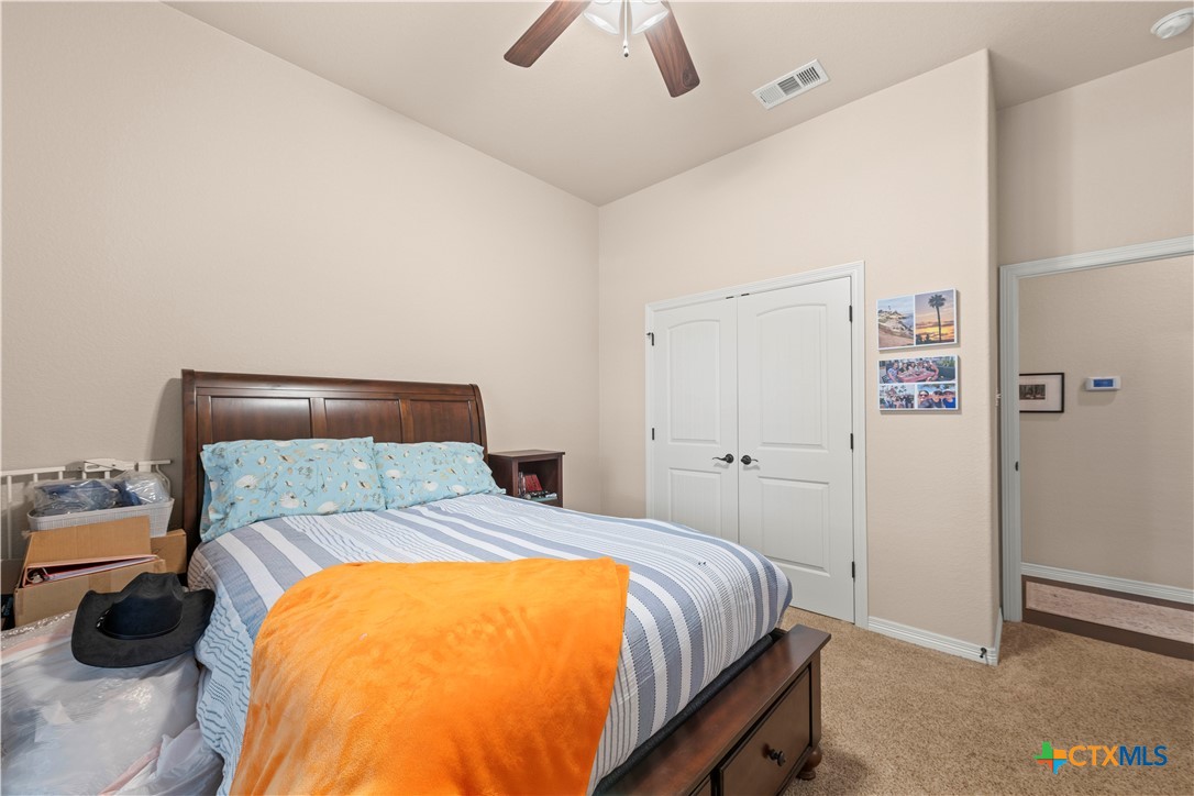 2649 Bowles Ranch Road Belton, TX 76513 - Photo 23 of 36 a bedroom with a bed and a chandelier
