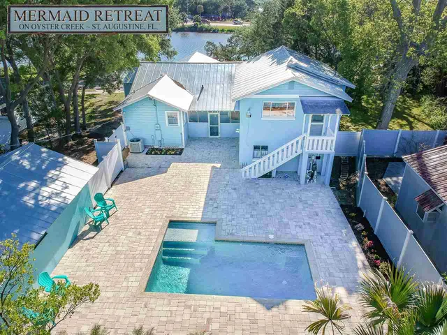 an aerial view of residential houses with outdoor space and lake view