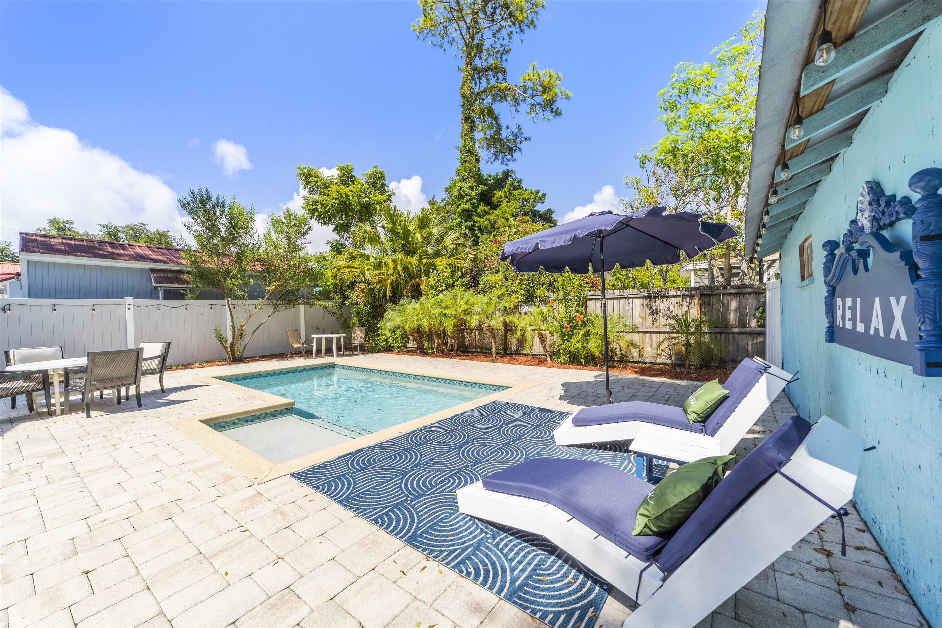 26 Rio Vista Drive St. Augustine, FL 32084 - Photo 70 of 91 a view of a patio with couches table and chairs under an umbrella with potted plants