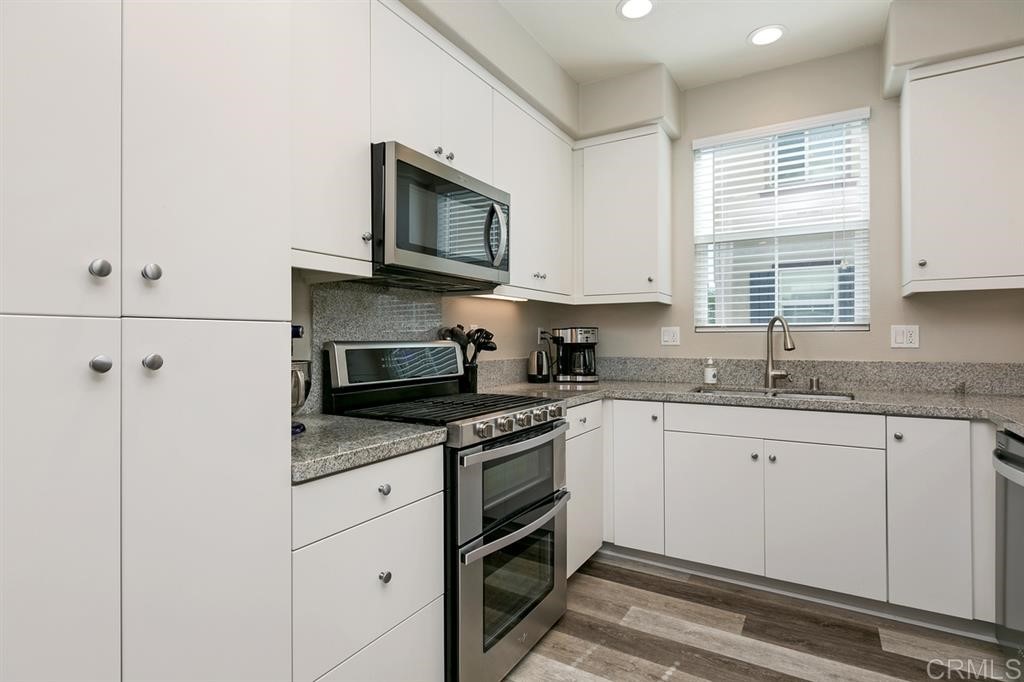 4222 Mission Ranch Way Oceanside, CA 92057 - Photo 9 of 22 a kitchen with granite countertop white cabinets and white appliances