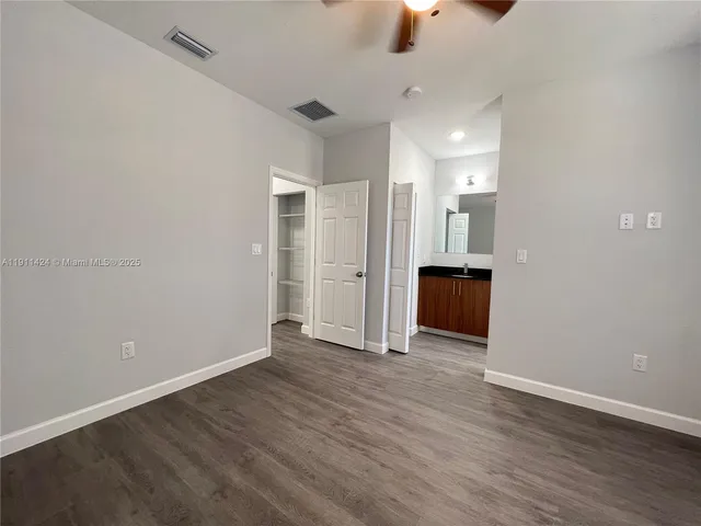 wooden floor in an empty room with a kitchen