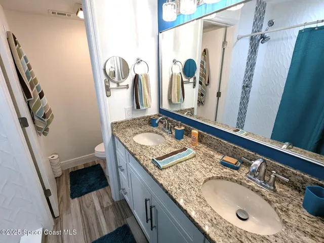 a bathroom with a granite countertop sink a mirror a vanity and a shower