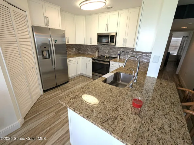 a kitchen with stainless steel appliances granite countertop a sink refrigerator stove microwave and refrigerator