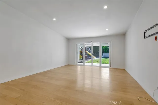 a view of an empty room with closet and wooden floor