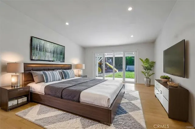 a bedroom with a bed and a flat screen tv