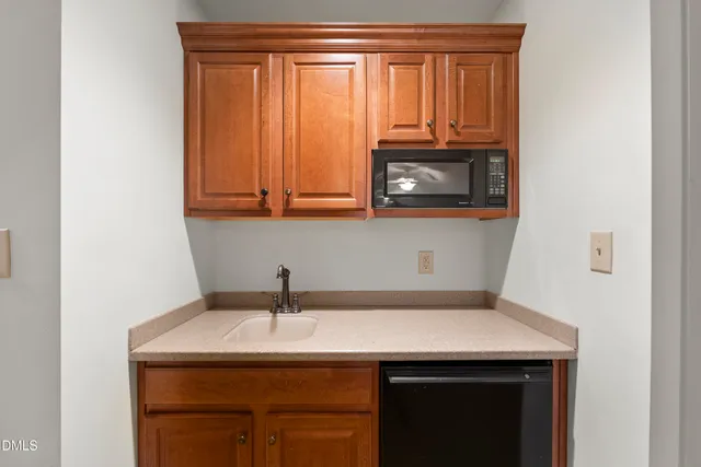 a kitchen with stainless steel appliances granite countertop wooden cabinets a sink and dishwasher with wooden floor
