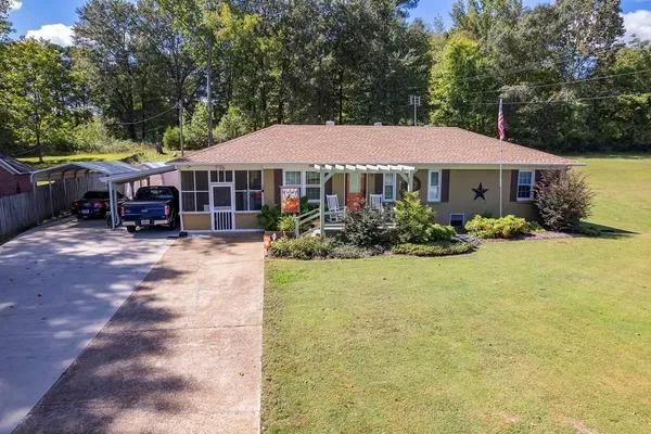 a view of a house with backyard and sitting area