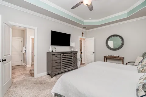a bedroom with a bed and a flat tv screen on dresser