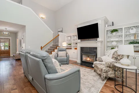 a living room with furniture a flat screen tv and a fireplace