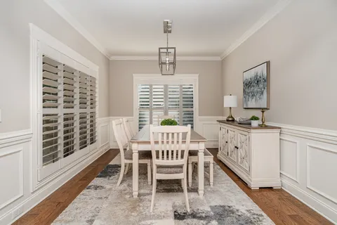 a dining room with furniture window and wooden floor