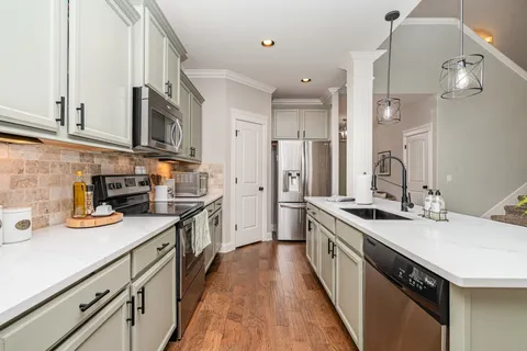 a kitchen with stainless steel appliances a sink stove top oven and cabinets