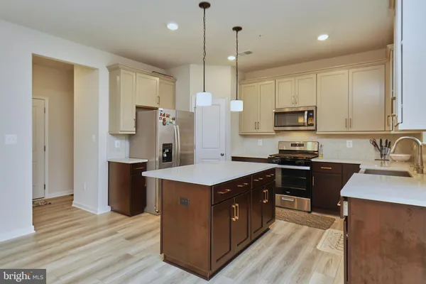 a kitchen with stainless steel appliances granite countertop a refrigerator stove and sink