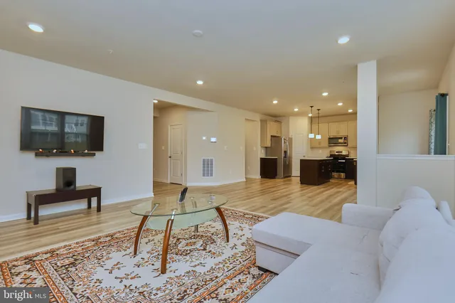 a kitchen with kitchen island granite countertop wooden floors stainless steel appliances and sink