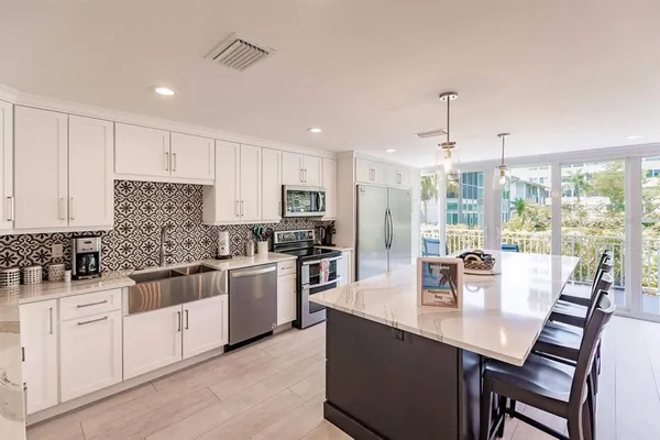 a kitchen with stainless steel appliances granite countertop a sink a stove and white cabinets