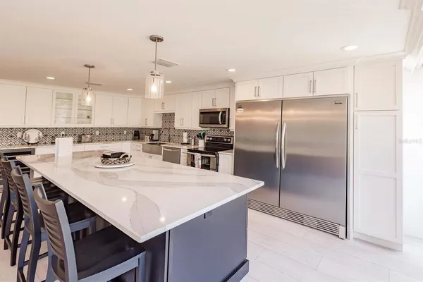 a kitchen with kitchen island a refrigerator a stove a sink and a refrigerator