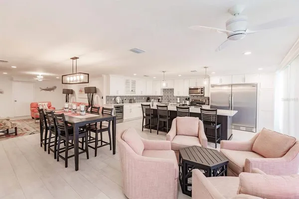 a living room with furniture kitchen view and a chandelier