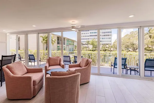 a living room with furniture and floor to ceiling windows