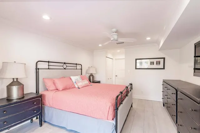 a bedroom with a bed and a lamp on a dresser