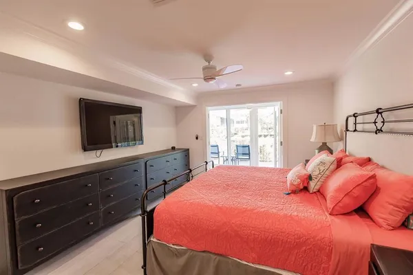 a bedroom with a bed a window and dresser