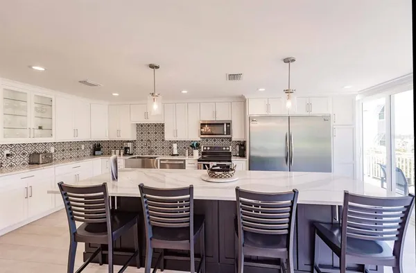 a kitchen with a dining table chairs stainless steel appliances and cabinets