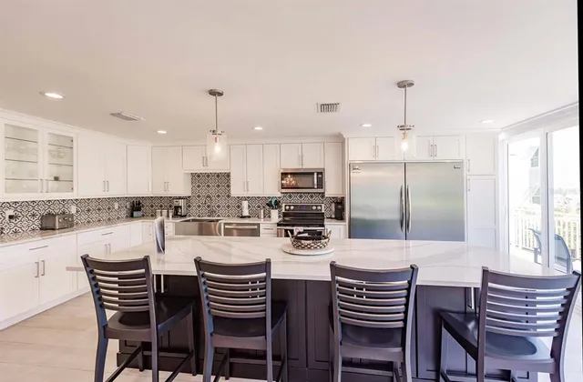 a kitchen with a dining table chairs stainless steel appliances and cabinets