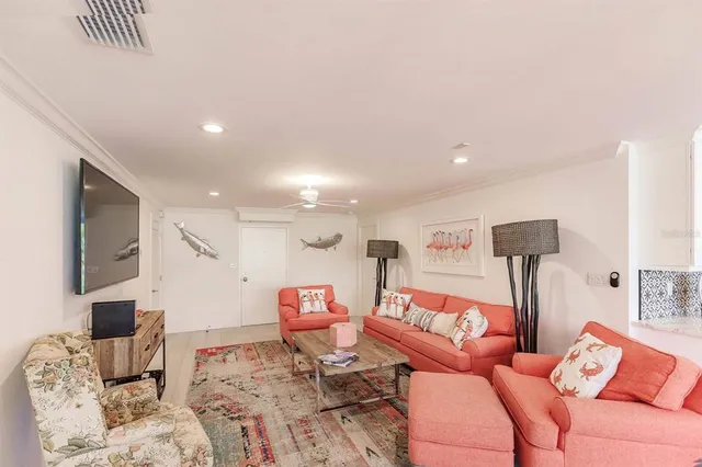 a living room with furniture a flat screen tv and a lamp