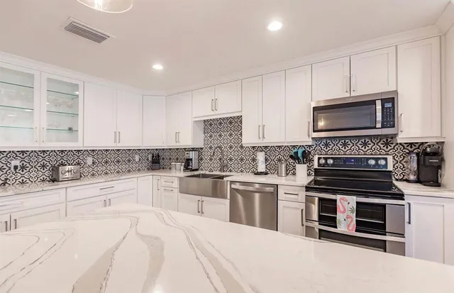 a kitchen with stainless steel appliances a stove sink microwave and cabinets