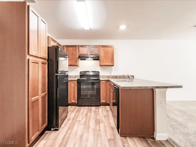 a kitchen with stainless steel appliances granite countertop a refrigerator a stove and a sink