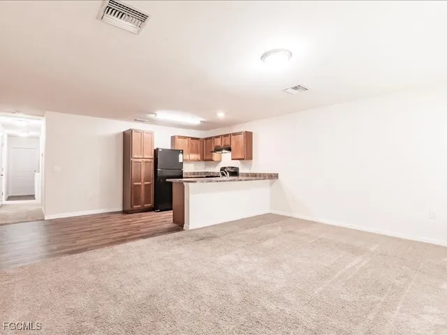 a view of kitchen with refrigerator cabinets and wooden floor