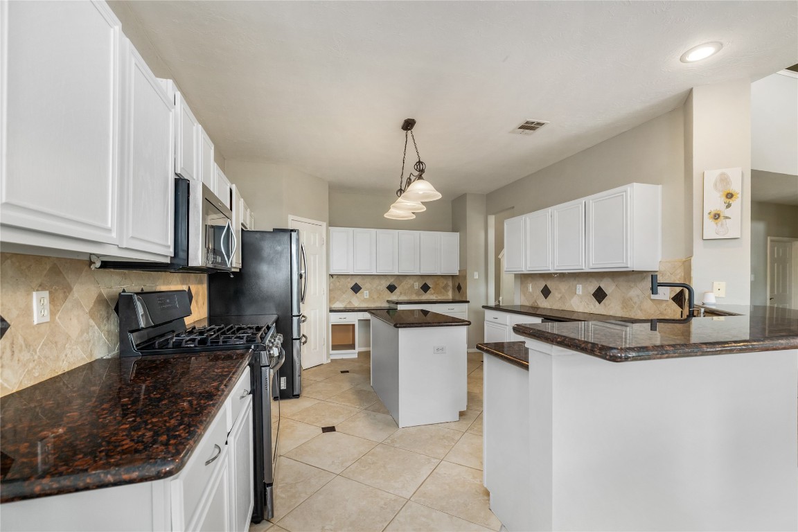 20735 Deauville Drive Spring, TX 77388 - Photo 11 of 33 The kitchen shines with freshly painted cabinets and sleek granite countertops, complemented by expansive cabinetry that provides ample storage for all your culinary needs.