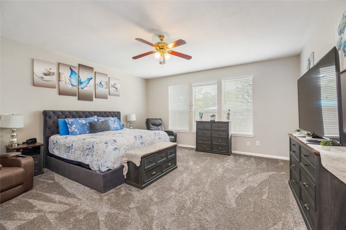 20735 Deauville Drive Spring, TX 77388 - Photo 13 of 33 The spacious primary suite features new carpeting and large windows that fill the room with natural light, creating a serene retreat to unwind and recharge.