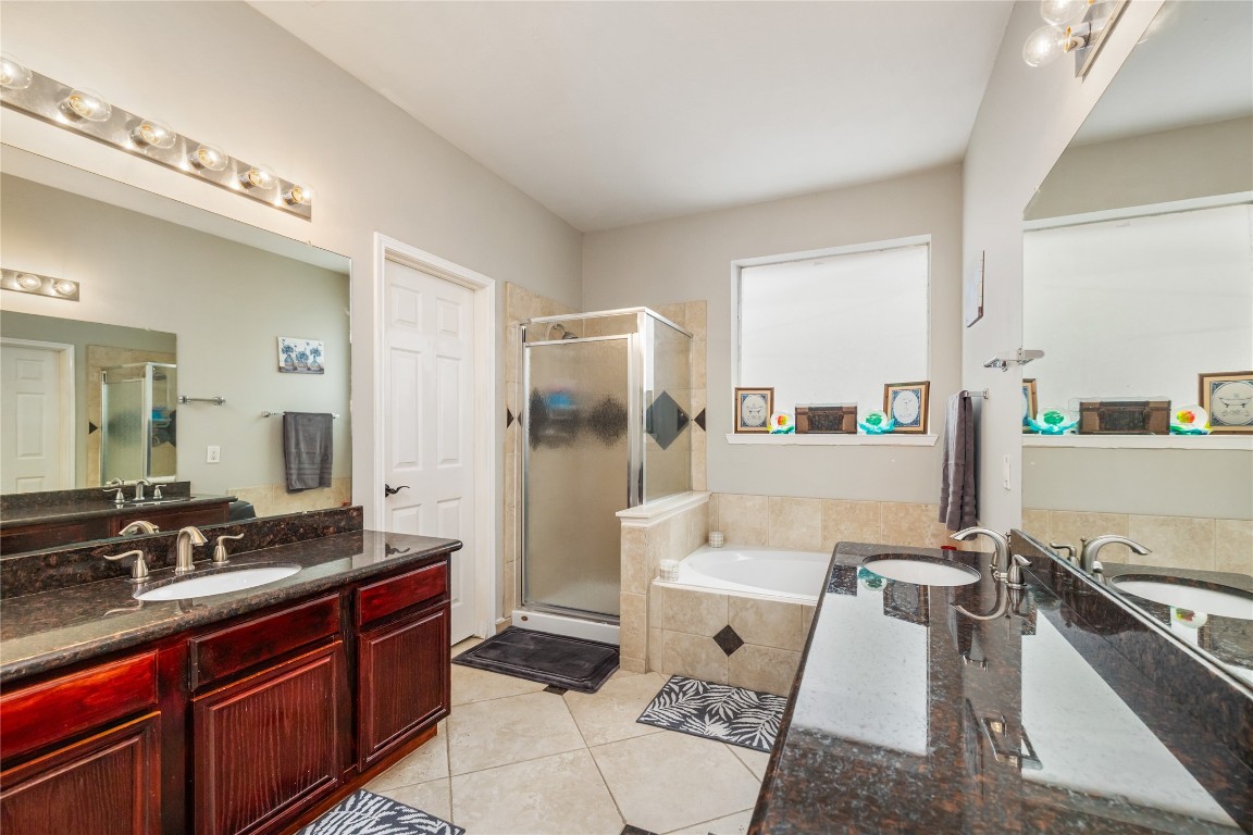 20735 Deauville Drive Spring, TX 77388 - Photo 14 of 33 The spacious primary bathroom boasts dual sinks, a separate soaking tub, vanity space, and a spacious walk-in shower—offering both luxury and convenience in your daily routine.