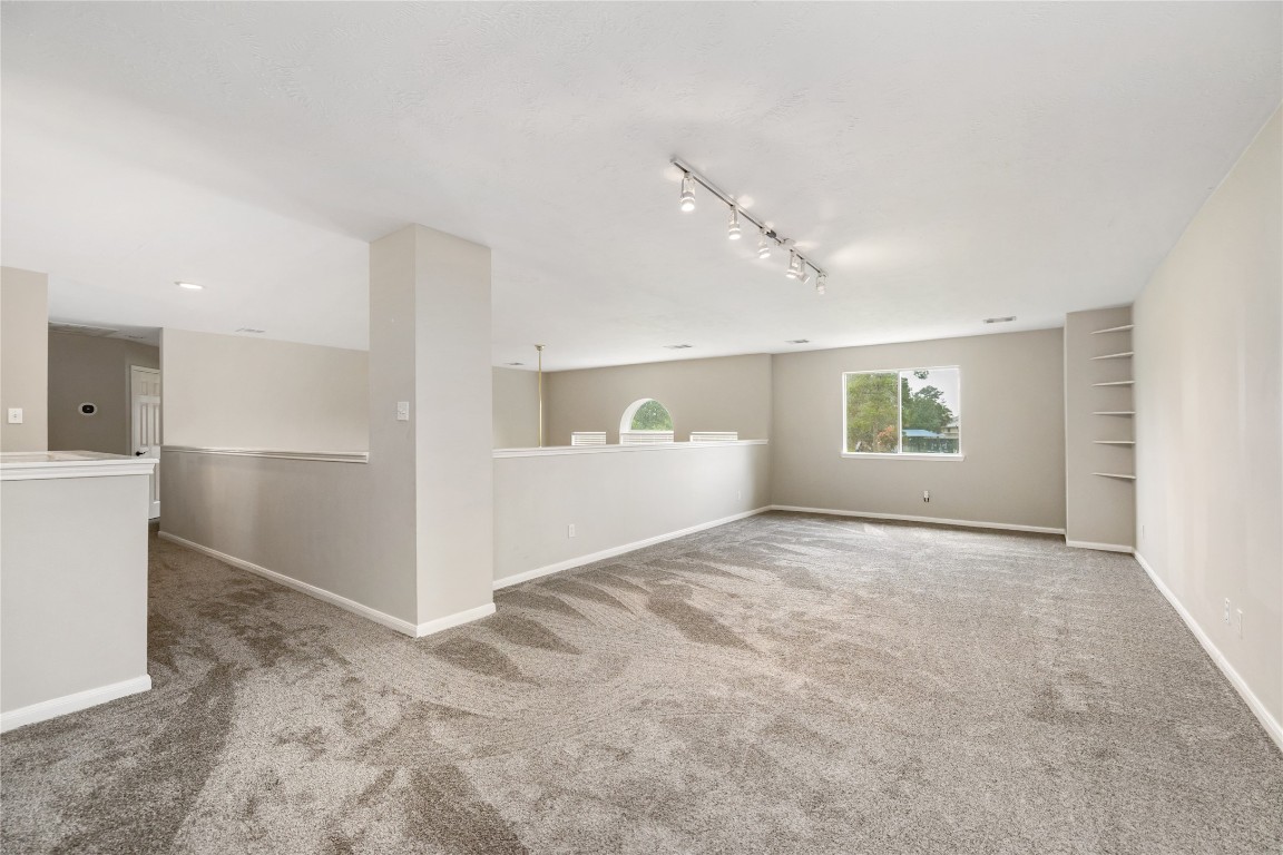 20735 Deauville Drive Spring, TX 77388 - Photo 16 of 33 The massive upstairs game room offers versatile space filled with natural light from large windows—perfect for play, relaxation, or a custom home gym.
