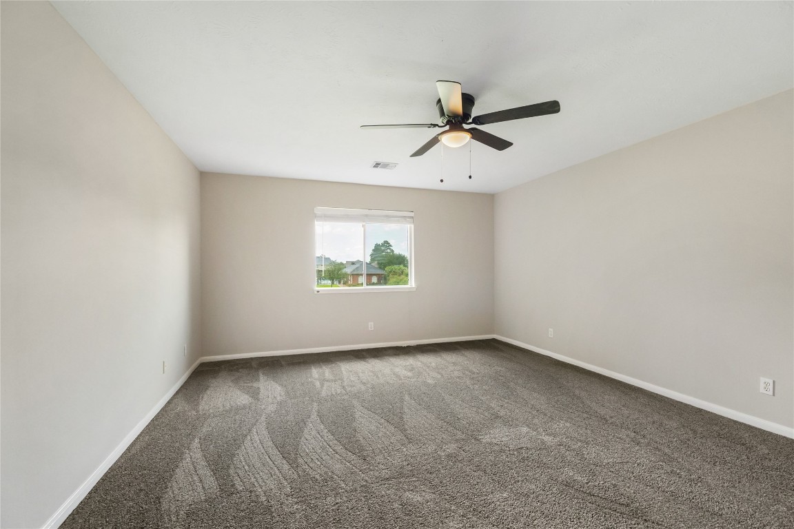 20735 Deauville Drive Spring, TX 77388 - Photo 19 of 33 Spacious secondary bedroom with fresh paint and new carpet offers plenty of room to grow, study, or relax—ideal for family, guests, or a home office.