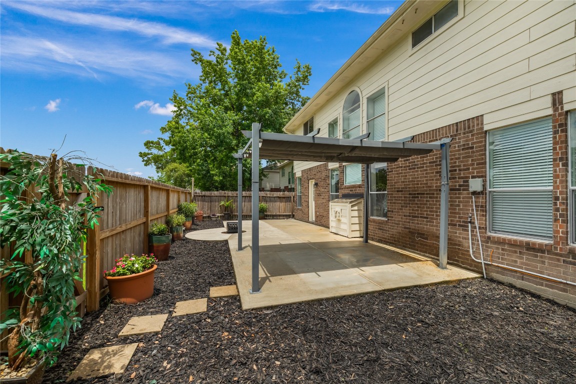 20735 Deauville Drive Spring, TX 77388 - Photo 26 of 33 A charming pergola offers covered patio space, while the new backyard fence—installed in 2024—features a gate that opens directly to community amenities, creating a seamless indoor-outdoor lifestyle.