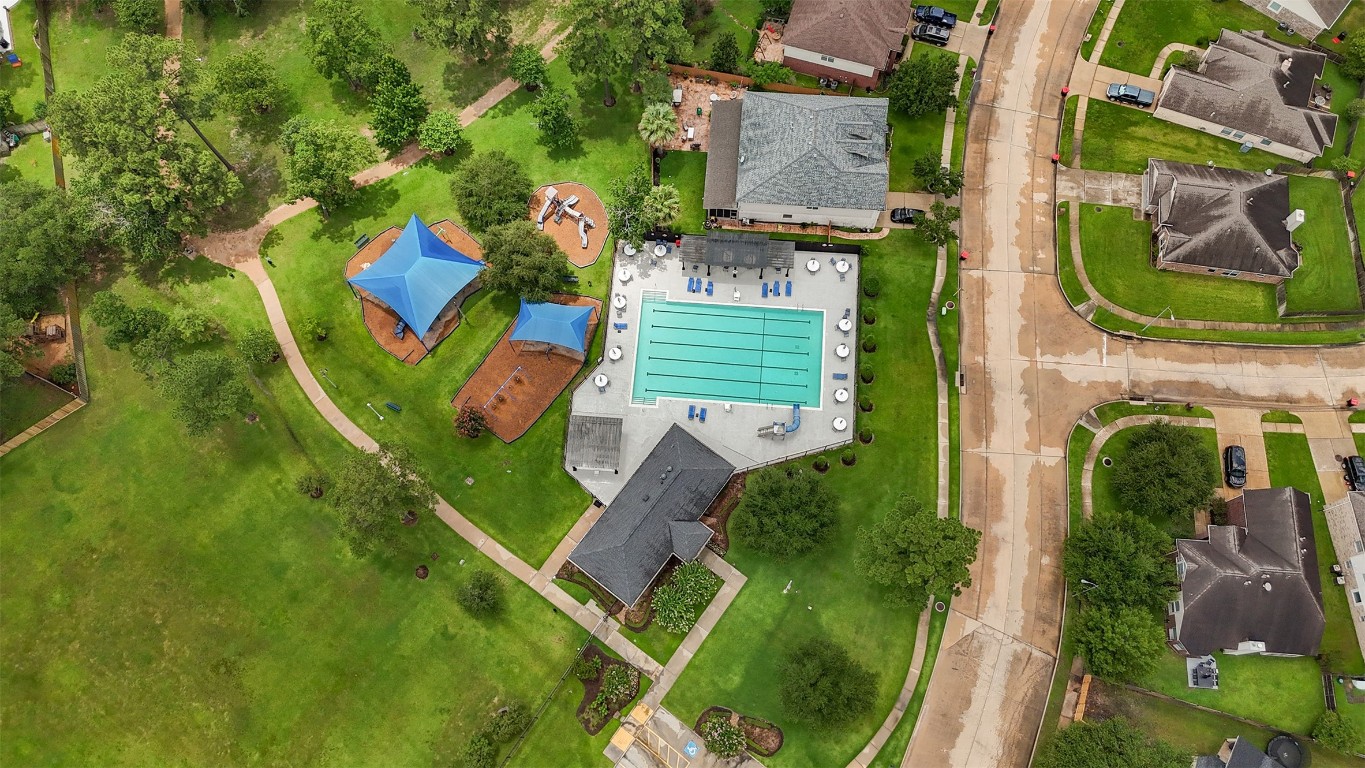 20735 Deauville Drive Spring, TX 77388 - Photo 28 of 33 The neighborhood pool invites you to cool off and unwind in a resort-style setting, while the playground nearby provides a safe, fun space for kids to explore and make lasting memories—all just steps from your backyard gate.