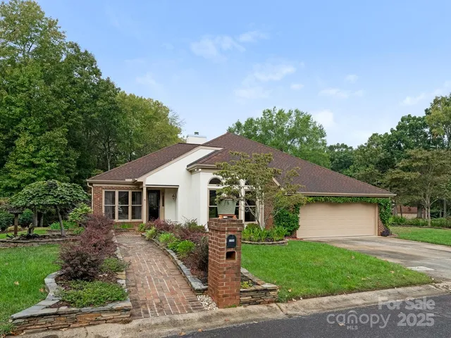 a front view of a house with a garden and yard