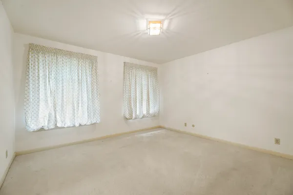 an empty room with a empty space and windows