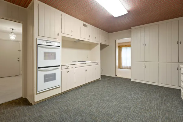 a view of a kitchen with white cabinets and white appliances