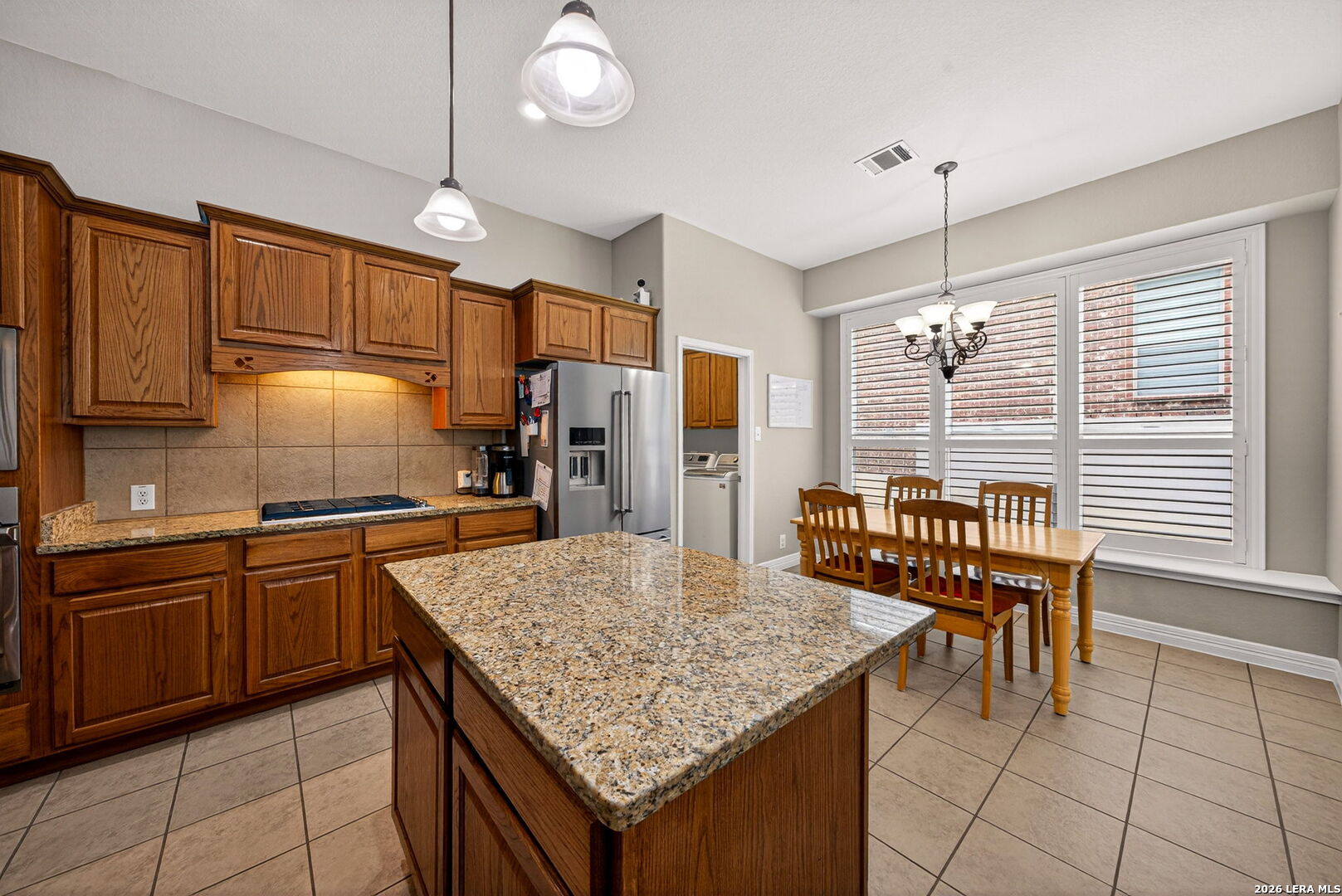 8715 Rancho De Taos Helotes, TX 78023 - Photo 1 of 40 a kitchen with granite countertop kitchen island stainless steel appliances a table chairs sink and cabinets