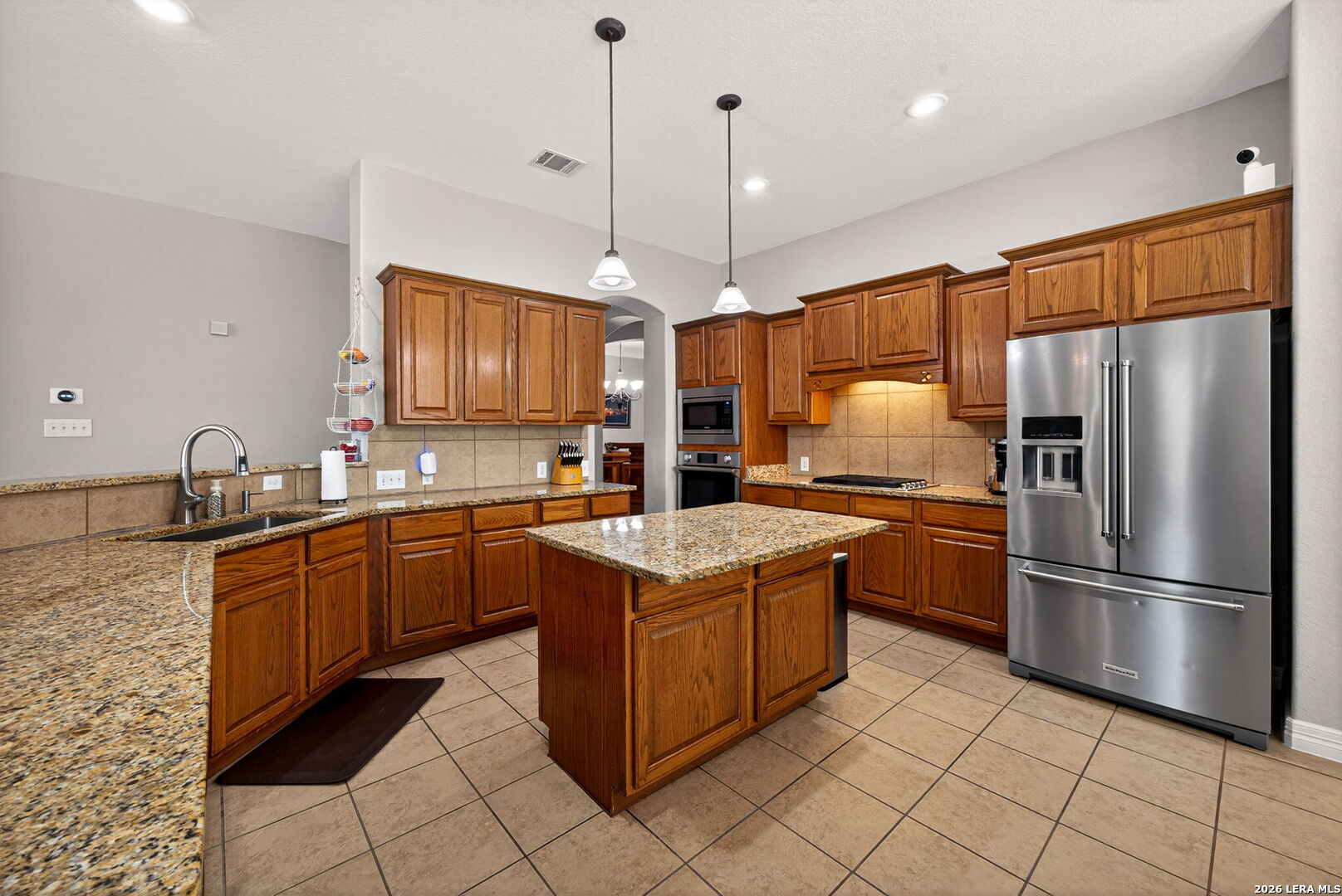 8715 Rancho De Taos Helotes, TX 78023 - Photo 11 of 40 a kitchen with stainless steel appliances granite countertop a stove a refrigerator and a sink