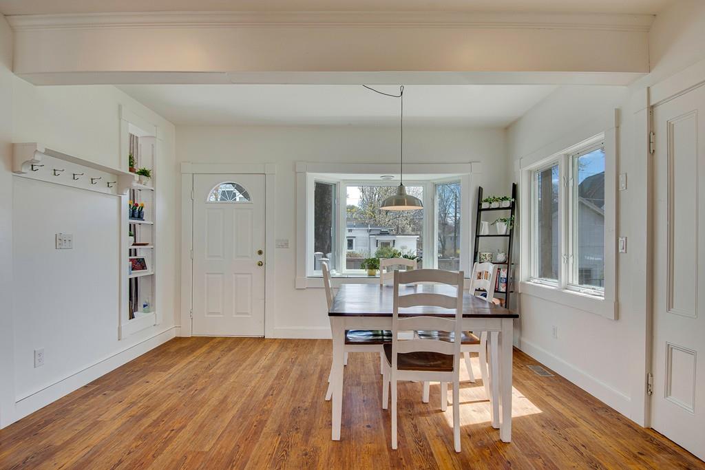 86 Pond Street Natick, MA 01760 - Photo 12 of 33 a dining room with wooden floor a chandelier a wooden table and chairs