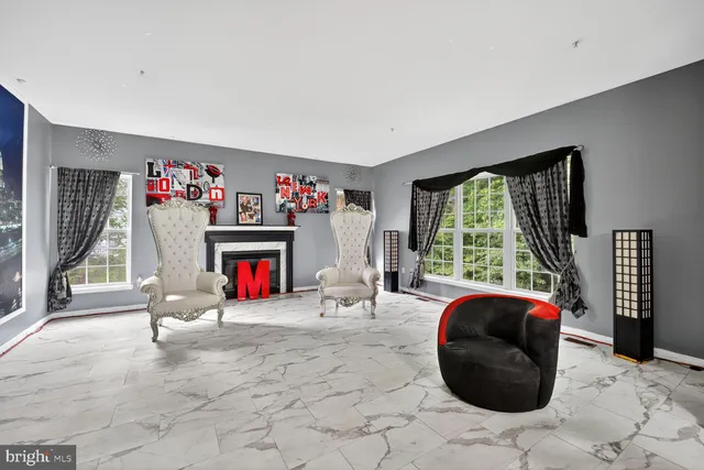 a living room with furniture a floor to ceiling window and a flat screen tv