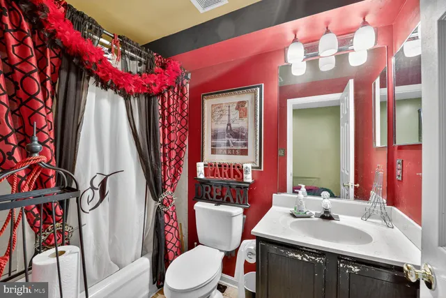 a bathroom with a sink vanity mirror and toilet