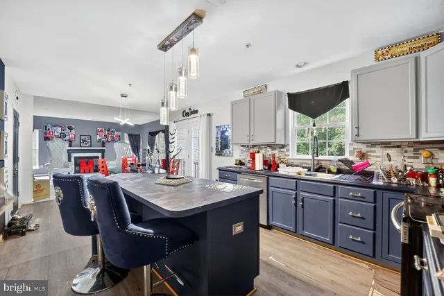 a kitchen with stainless steel appliances granite countertop a sink dishwasher and a refrigerator with wooden cabinets