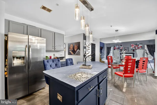 a kitchen with stainless steel appliances granite countertop a table chairs and a refrigerator