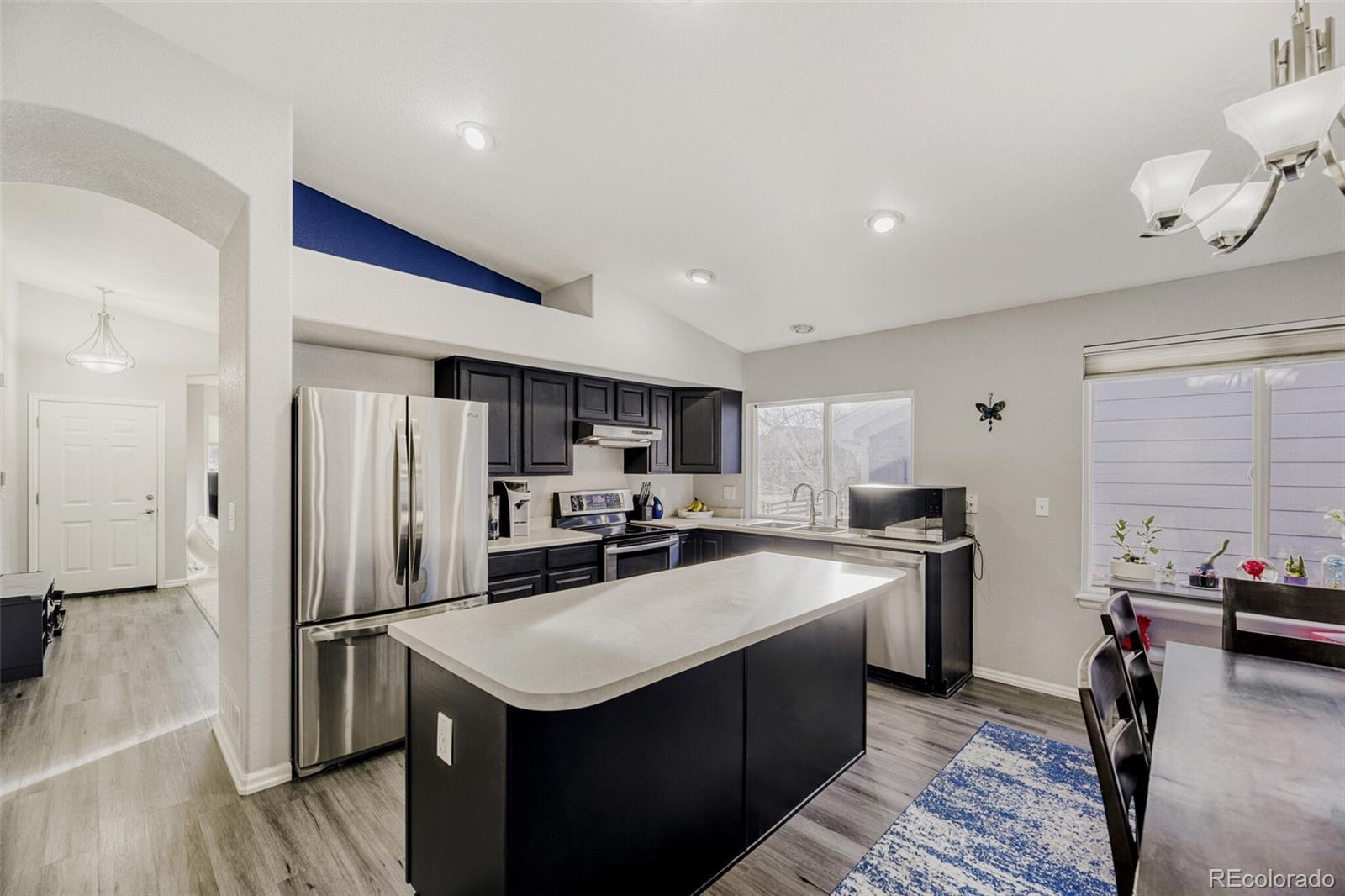 7085 Leopard Gate Lone Tree, CO 80124 - Photo 3 of 26 a kitchen with stainless steel appliances granite countertop a sink stove refrigerator and cabinets