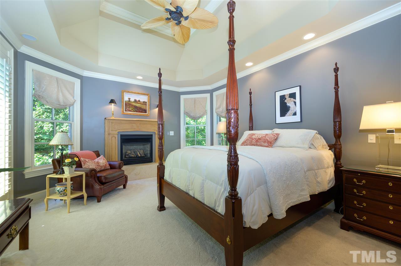 317 Homestead Drive Cary, NC 27513 - Photo 11 of 30 a spacious bedroom with a bed and a fireplace