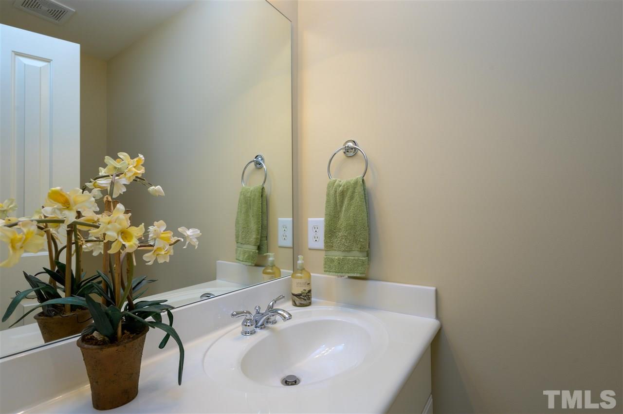 317 Homestead Drive Cary, NC 27513 - Photo 23 of 30 a bathroom with a sink a mirror and a potted plant