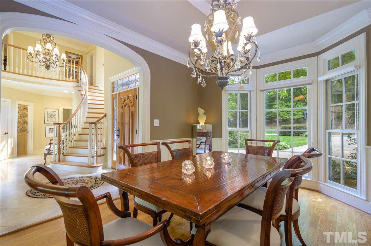 317 Homestead Drive Cary, NC 27513 - Photo 4 of 30 a dining room with furniture a chandelier and wooden floor